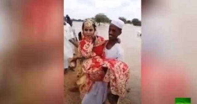 فيديو.. عريس سودانى يحمل عروسه فوق السيول بالخرطوم