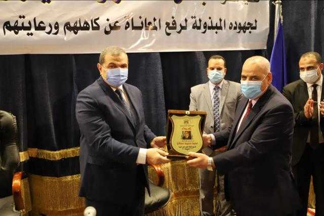 سعفان ومحافظ البحيرة يتبادلان الدروع في حفل تسليم بوالص التأمين للصيادين والعمالة غير المنتظمة