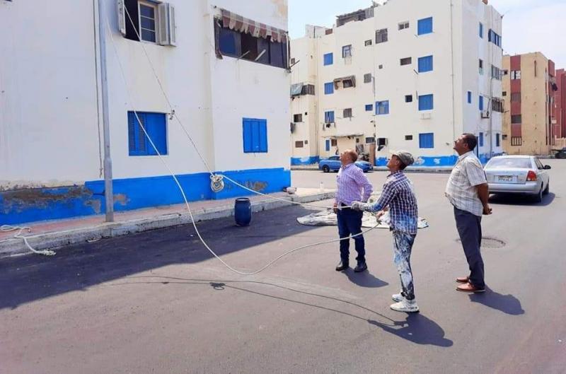 استمرار العمل في طلاء عمارات المنطقة السابعة بلون موحد في بورسعيد | صور