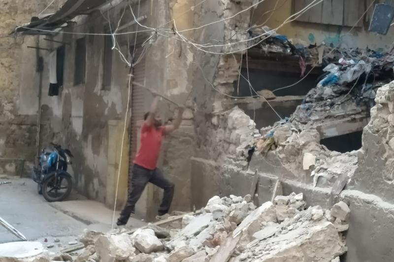 إزالة الأجزاء المتهالكة من عقار قديم بحارة الشيخ دويك بنطاق حي الجمرك بالأسكندرية