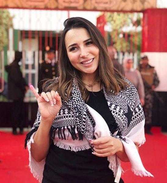ساندي تدلي بصوتها في انتخابات الرئاسة مرتدية الشال الفلسطيني