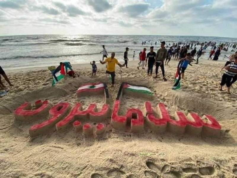 سلاما بيروت.. جريح فلسطينى يتضامن مع اللبنانيين بنحت لوحة على شواطئ غزة