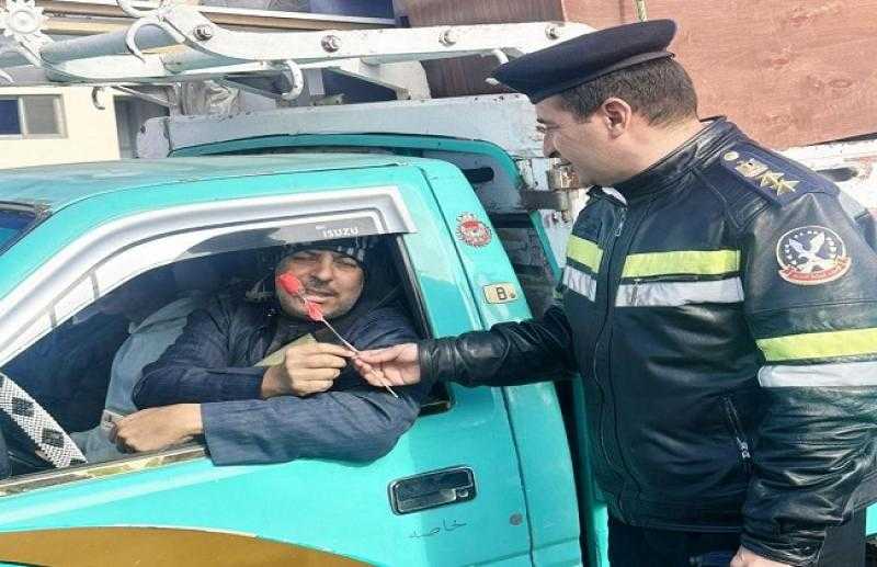 المرور يحتفل بعيد الشرطة بتوزيع الورود والشوكولاتة على قائدي السيارات